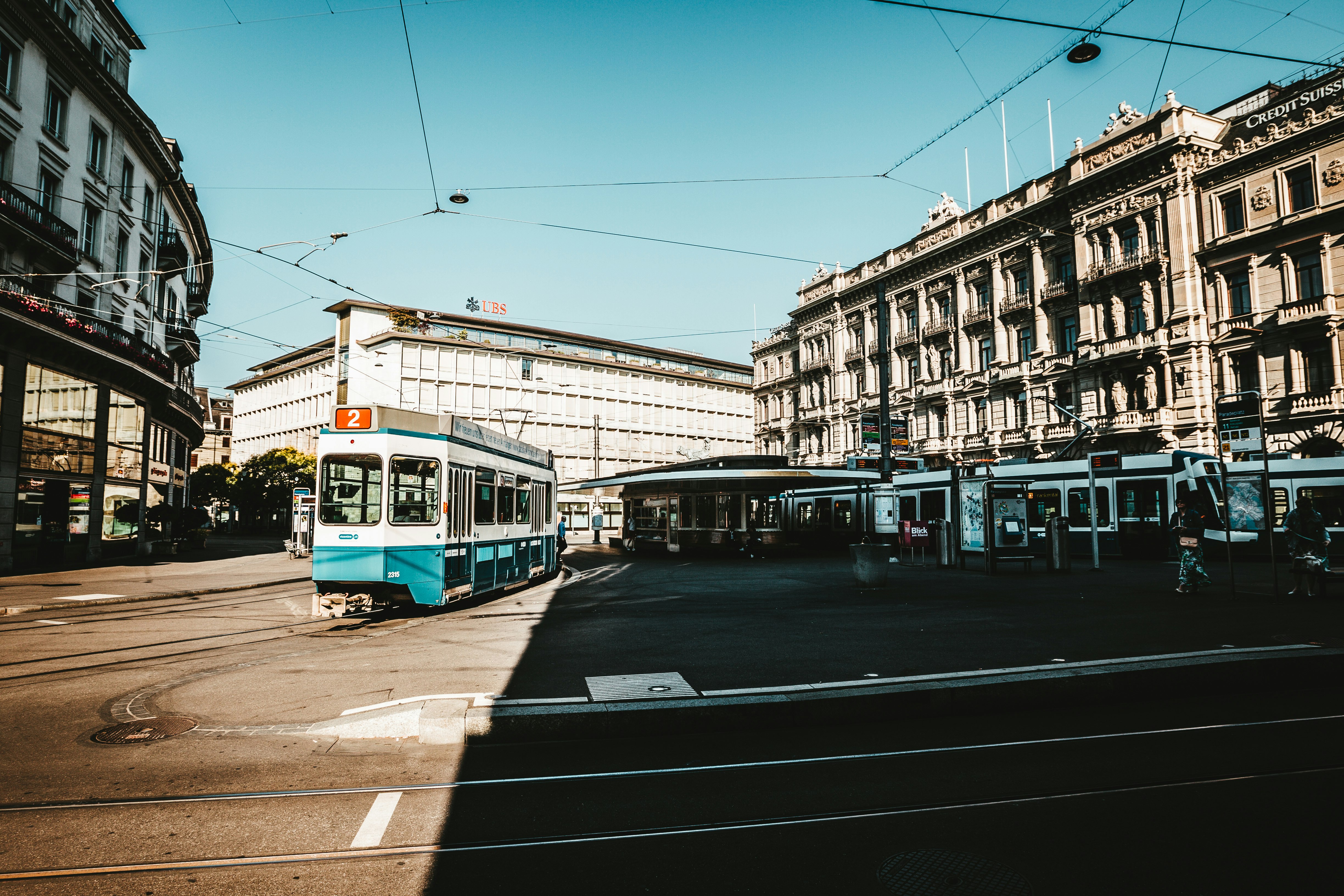 train at middle of street surrounded by buildings